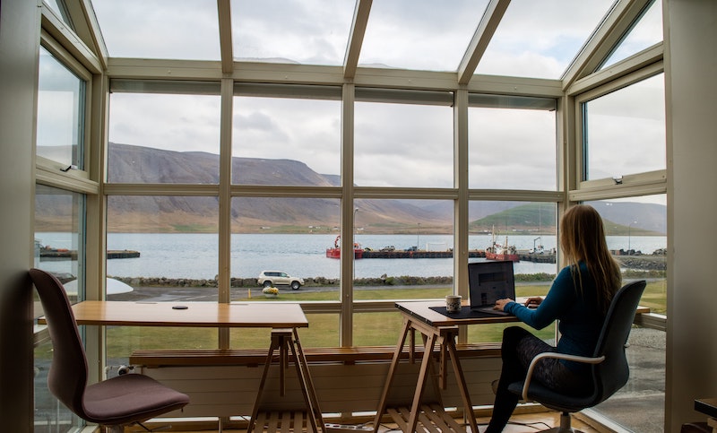Woman on a remote team training from a table with a view