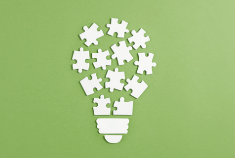 Puzzle pieces shaped like a lightbulb illustrate how teams need accountability to be successful