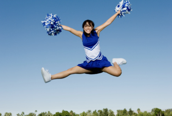 This high-flying cheerleader is cheering on her team with pom-poms in blue and white.